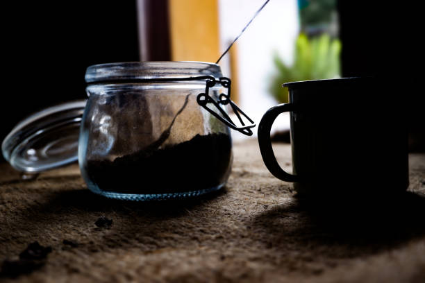 An enamel cup and a jar containing coffee