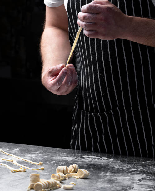 istock Chef holding freshly prepared pasta in his hands on a dark background 2160405515