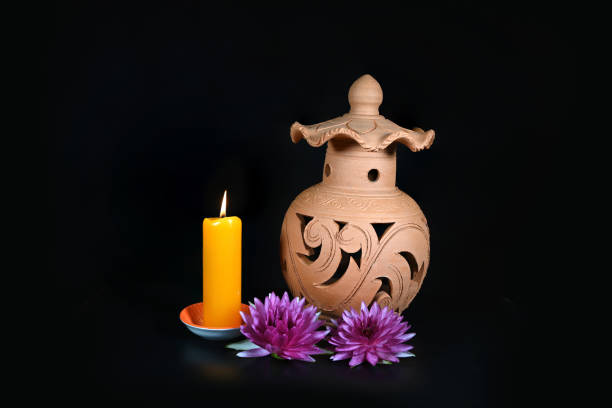Traditional pottery earthenware with beautiful water lily and burning candle. Thailand's striped lamps are made of clay.