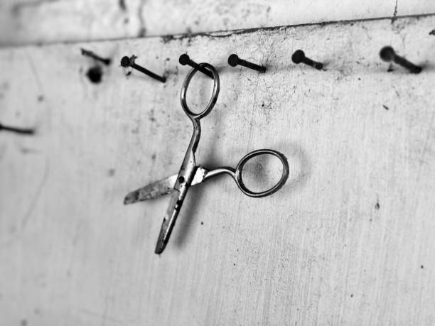 An old pair of scissors hanging on a rusty nail