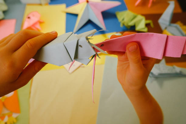 istock primary school boy playing with origami that he made himself 2160414112