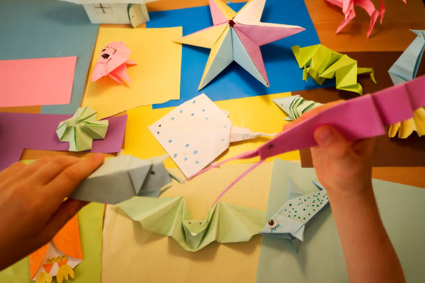 istock primary school boy playing with origami that he made himself 2160414113