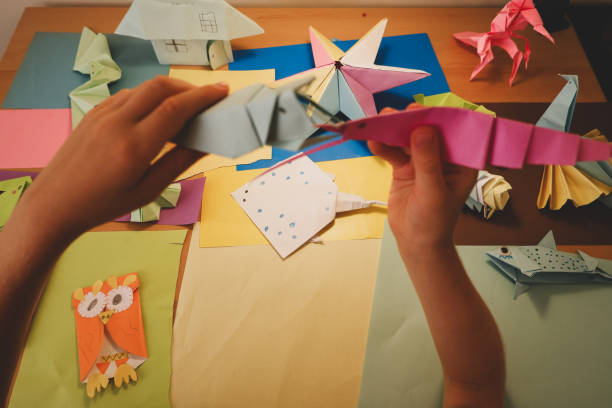 istock primary school boy playing with origami that he made himself 2160414114
