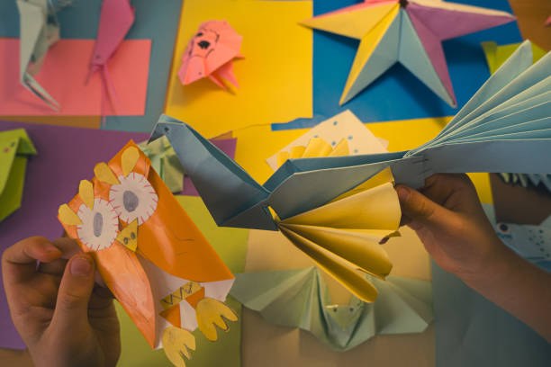 primary school boy playing with origami that he made himself