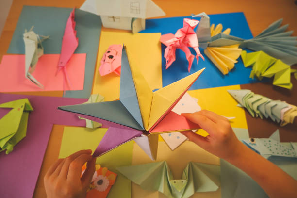 istock primary school boy playing with origami that he made himself 2160414253
