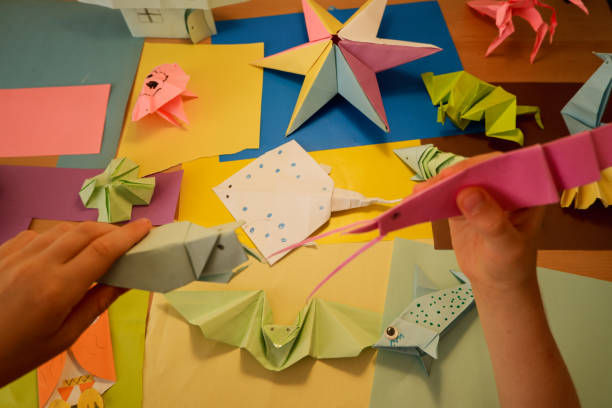 istock primary school boy playing with origami that he made himself 2160416456