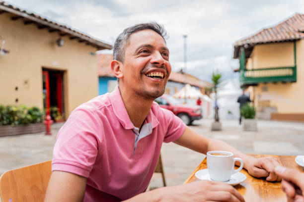 istock Mature man talking with friends at sidewalk cafe 2160417749