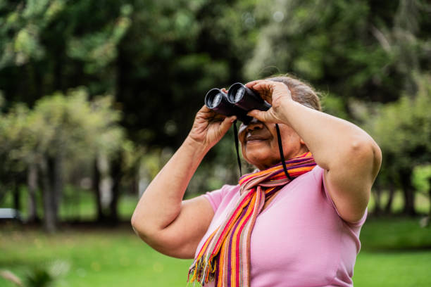 Senior woman looking through binoculars outdoors