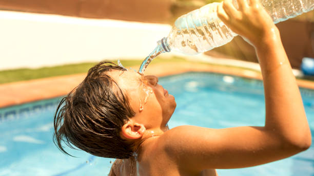 istock boy cooling off with water due to extreme heat wave 2160421405