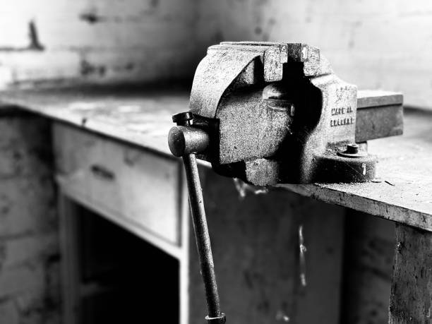 An old metal vice on a workbench in a domestic garage
