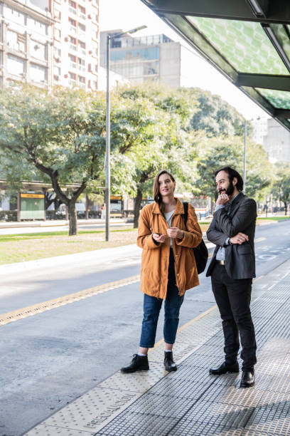 istock Coworkers talking on bus stop 2160422353