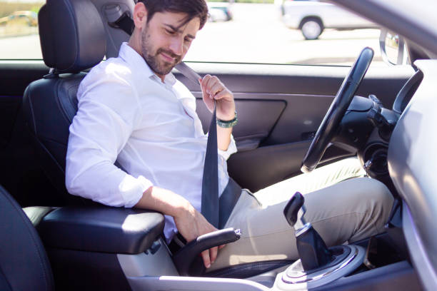 istock Businessman fastening seat belt while sitting inside car 2160423394