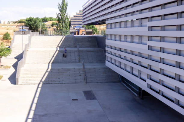Businessman is walking up stairs outside a modern building with a briefcase