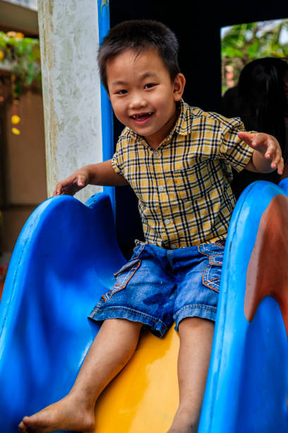 istock Vietnamese little boy having fun on slide, South Vietnam 2160423875