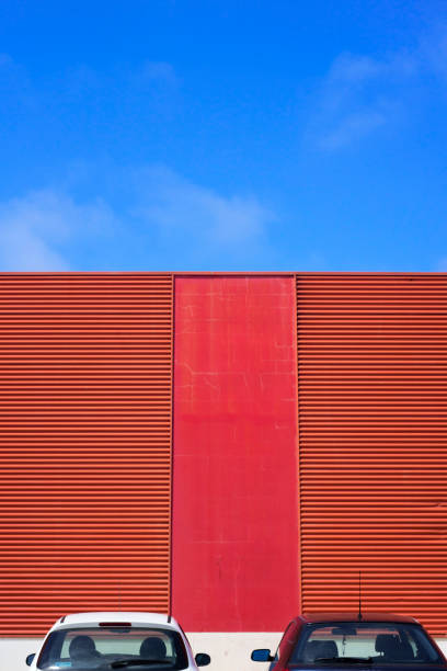 istock Cars parked by red metal facade 2160424376