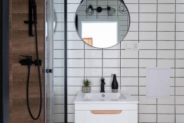 istock Bathroom with brick wall, circle mirror and bathroom sink in industrial style. Interior decor at new home. 2160425192
