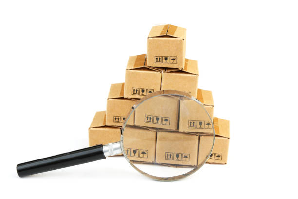 istock Many carton boxes under magnifying glass isolated on white. 2160426579