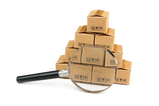 istock Many carton boxes under magnifying glass isolated on white. 2160426582