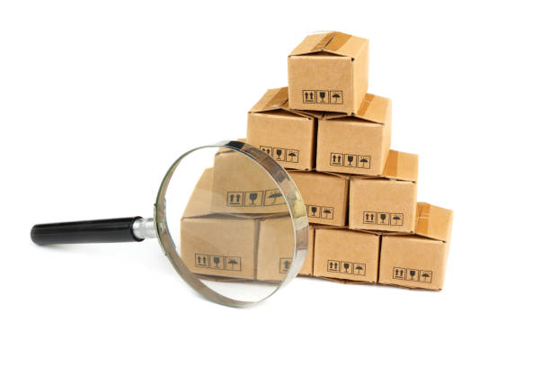 istock Many carton boxes under magnifying glass isolated on white. 2160426583