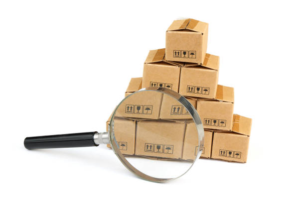 istock Many carton boxes under magnifying glass isolated on white. 2160426584