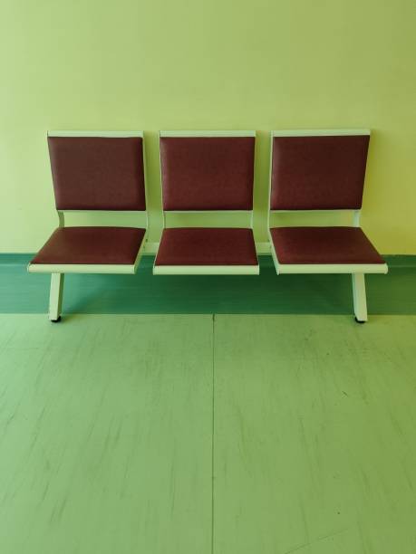 There is an empty metal seat in the subway waiting room