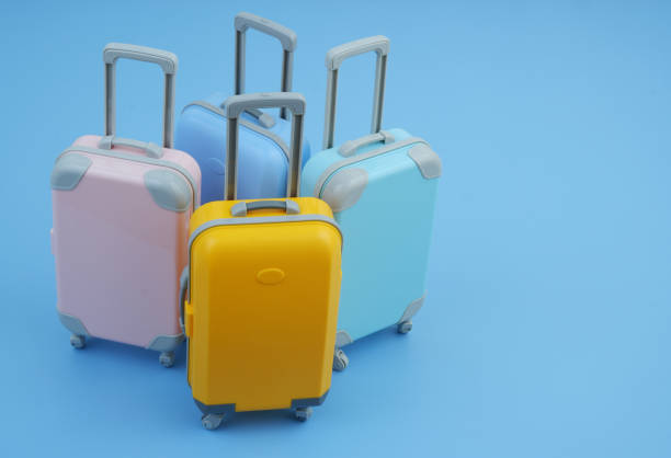 istock Many different colorful suitcases on blue background. 2160427189