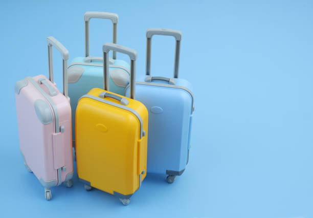 istock Many different colorful suitcases on blue background. 2160427190