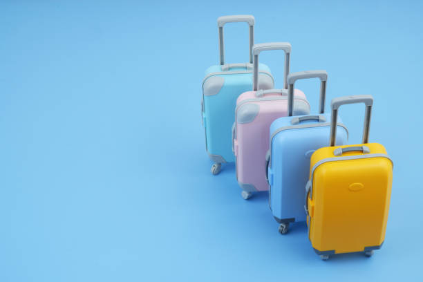 istock Many different colorful suitcases on blue background. 2160427211