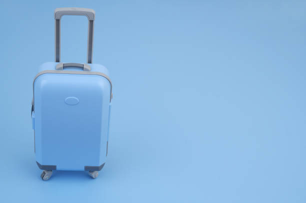 istock Shopping cart with suitcase on blue background close up. 2160427444