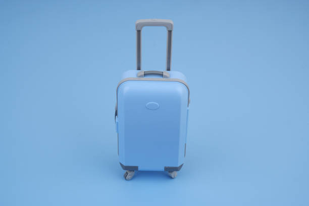 istock Shopping cart with suitcase on blue background close up. 2160427446