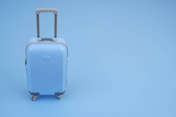 istock Shopping cart with suitcase on blue background close up. 2160427448