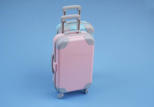 istock Pink and blue suitcases on blue background. T 2160427483