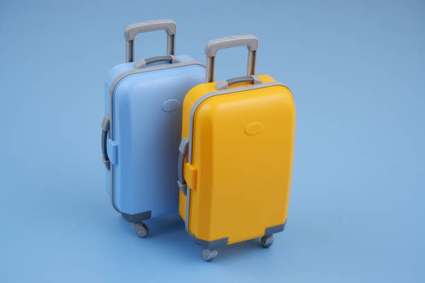 istock Blue and orange travel suitcases on blue background. 2160427568