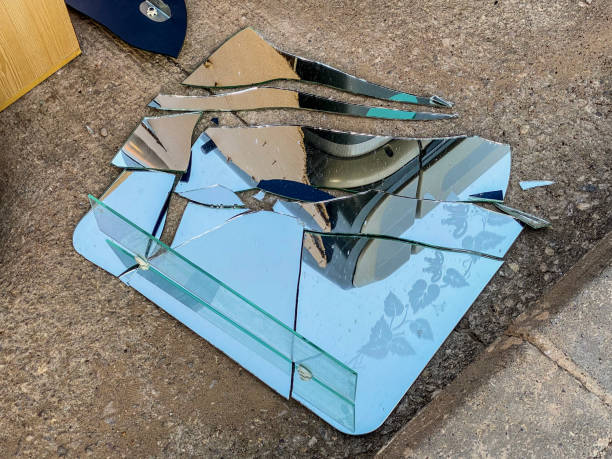 High angle view of a broken mirror thrown over the asphalt