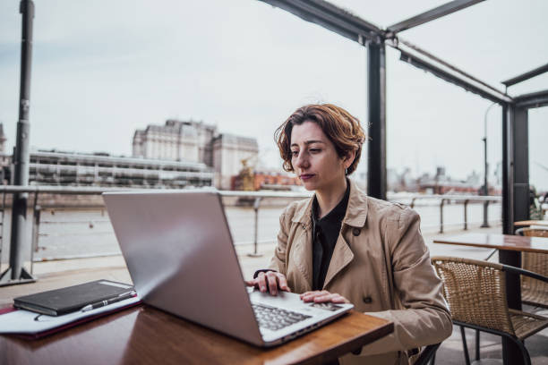 istock Businesswoman using laptop on sidewalk cafe 2160430094
