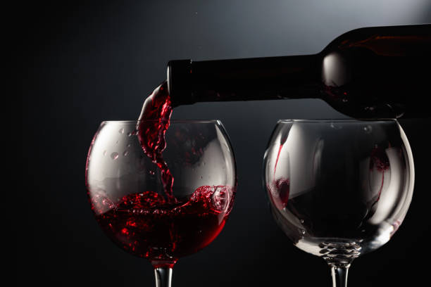 istock Pouring red wine into a wine glass. 2160431366