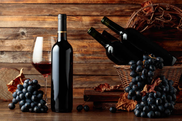 istock Red wine and blue grapes on an old wooden table. 2160431445