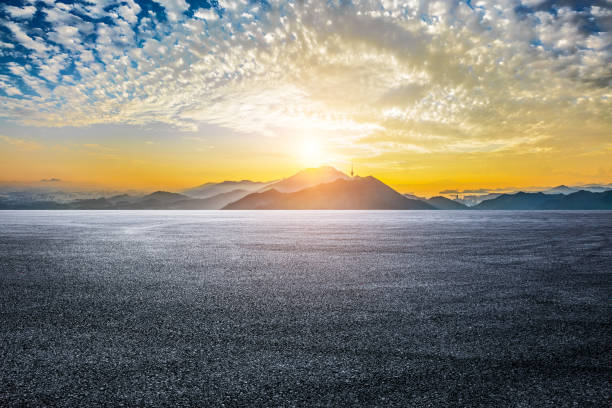 istock Empty asphalt road and mountains with city skyline 2160432175