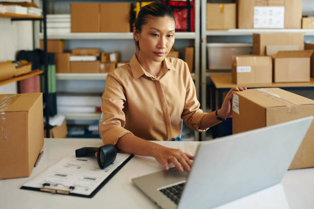 istock Woman Entering Data Of Parcel In Laptop 2160433267