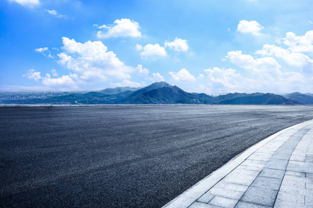 istock Empty asphalt road and mountains with city skyline 2160433613