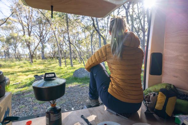 istock Woman Relaxing in Camper Van with Forest View 2160434756