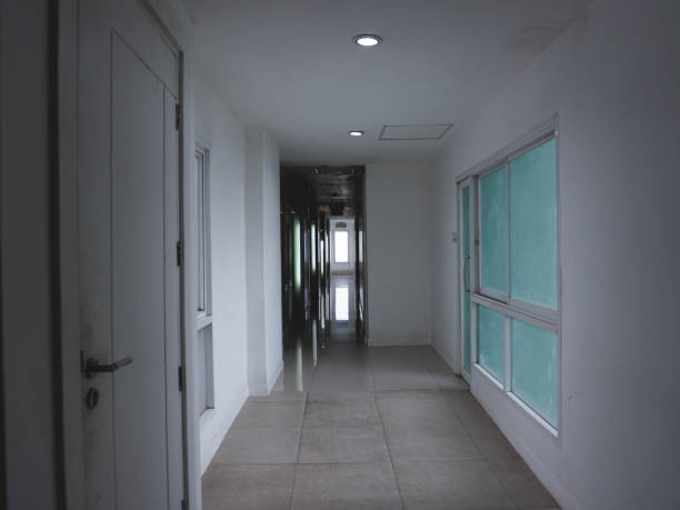 Dimly lit corridor inside the hotel to enter the rooms, with light streaming in through the windows.
