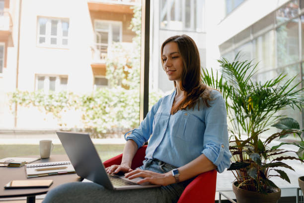istock Young professional working remotely from a modern office space filled with natural light and plants 2160437426