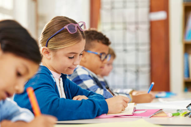 istock School girl doing homework in classroom 2160437657