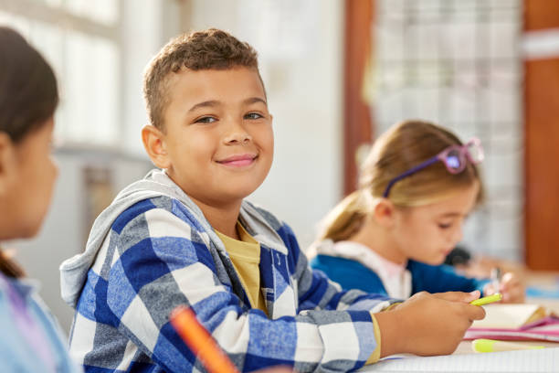 istock Portrait of elementary school boy writing in classroom 2160437726