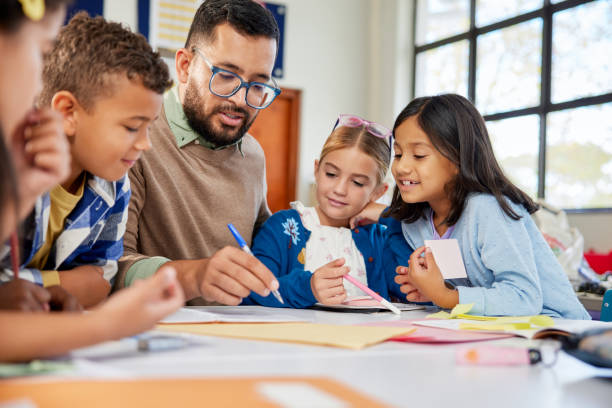 istock Teacher checking children homework at school 2160438006