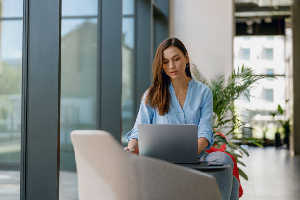 istock A woman is seen inside a contemporary green office, concentrating on work using a laptop 2160438140