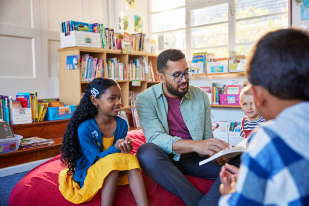 istock Teacher reading a fairy tale to pupil at school library 2160439087