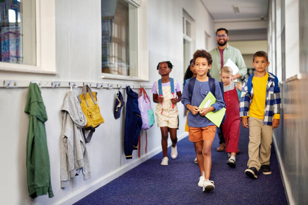 istock School kids walking in hallway with teacher 2160439317