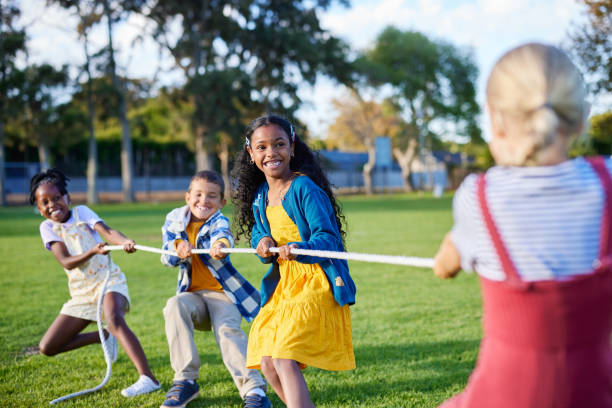 istock Happy children playing tug of war 2160439539
